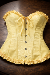 Corsé Rosalind Amarillo – sobre mesa de madera
